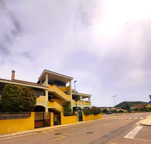 ヴィッラシミーウスにあるAppartamenti Il Glicine Villasimiusの通路脇の黄色い建物