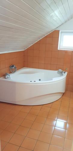 a large white tub in a room with an attic at Pataki House in Mórahalom