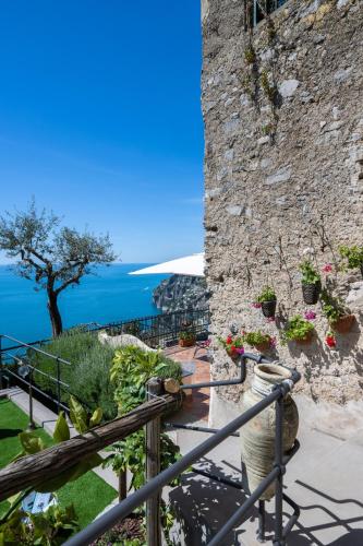 a stone building with plants and flowers on a balcony at YourHome - Casa Ivi Positano in Positano