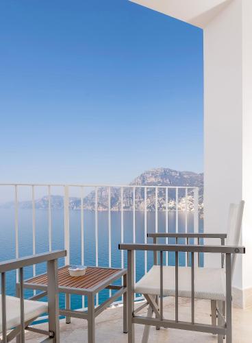 a table and chairs on a balcony with a view of the ocean at Casa Angelina in Praiano