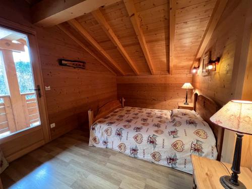 ラ・クリュサにあるL'Aulp De Suz 1 - Demi chaletの木造キャビン内のベッド1台が備わるベッドルーム1室を利用します。