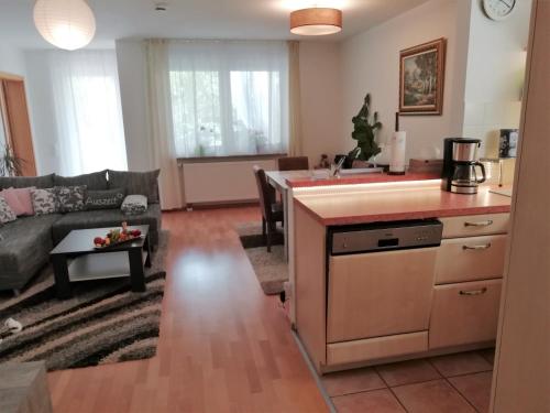 eine Küche und ein Wohnzimmer mit einem Sofa und einem Tisch in der Unterkunft TOM13 in Köngen
