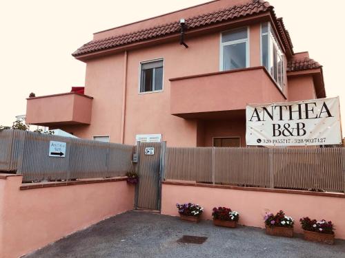 una casa rosa con una valla y un cartel en ella en Anthea B&B, en Ercolano