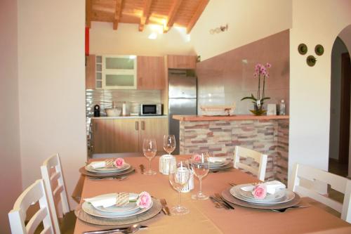 a dining room table with plates and wine glasses at Quinta das Alfambras in Aljezur