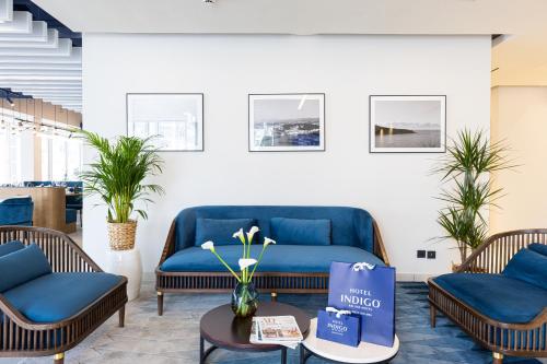 a living room with two blue couches and a table at Hotel Indigo Cagnes-sur-Mer by IHG in Cagnes-sur-Mer