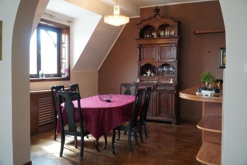 ein Esszimmer mit einem roten Tisch und Stühlen in der Unterkunft Marija Delux 3 in Srbobran