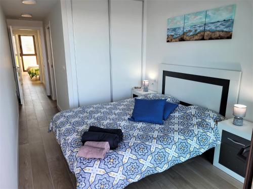 - une chambre avec un lit doté de draps et d'oreillers bleus et blancs dans l'établissement Los Flamencos Sea View Apartment, à Carthagène