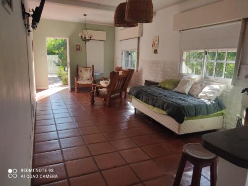 1 dormitorio con 1 cama, mesa y sillas en Casa Quinta Marie Rose en Mercedes