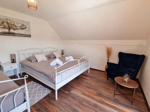 1 dormitorio con 1 cama y 1 silla en Kuća za odmor Baron, en Kutjevo