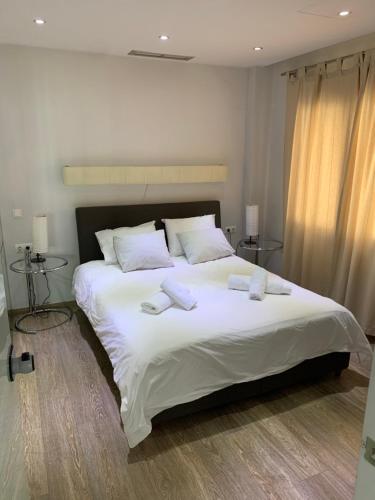 a bedroom with a large white bed with towels on it at Olvias Apartment in Athens