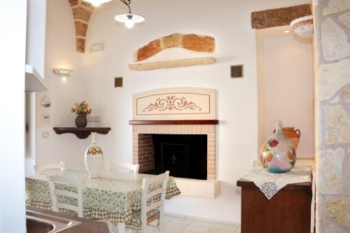 a living room with a table and a fireplace at Casa vacanze Elisir in Specchia