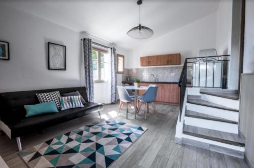 un salon avec un canapé noir et une table dans l'établissement Petite maison de vacance vue mer, au Lavandou
