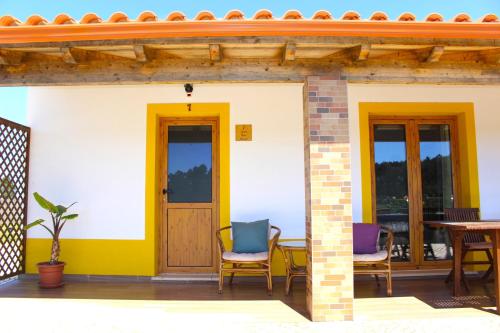 a house with two chairs and a table on a patio at Quinta das Alfambras in Aljezur