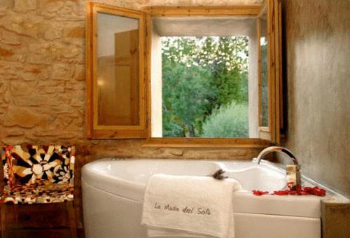 a bathroom with a bath tub and a window at Fonda La Masia Del Sola in Monistrol de Calders