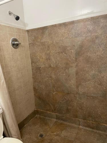 a bathroom with a shower with a tiled shower at Budget Inn in Monroeville