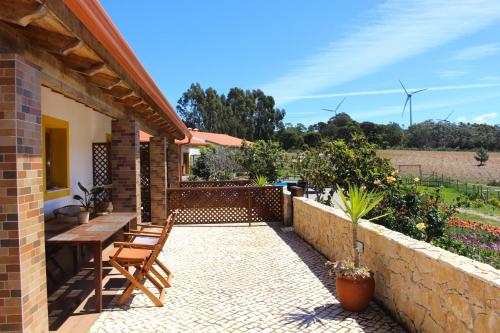 a patio with a wooden table and chairs at Quinta das Alfambras in Aljezur