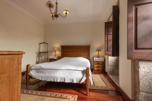 a bedroom with a bed and a chandelier at Quinta Do Bento Novo - Casa de Campo - Turismo Rural in Viana do Castelo