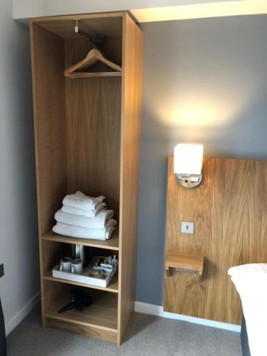 a room with a book shelf with folded towels at Loch Lomond Hotel in Balloch