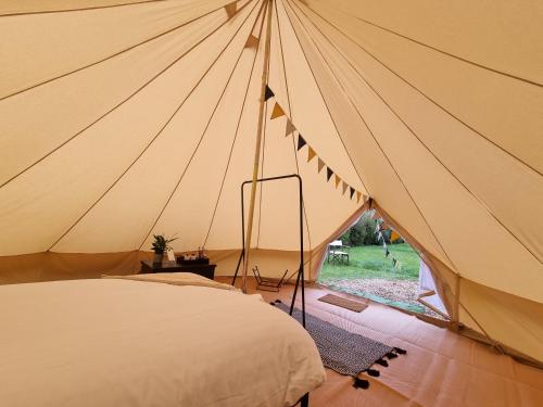 ein großes Zelt mit einem Bett in einem Zimmer in der Unterkunft Dartmoor Halfway Campsite in Newton Abbot