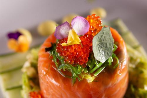 a close up of a piece of salmon with flowers on it at Valtos Beach Hotel in Parga