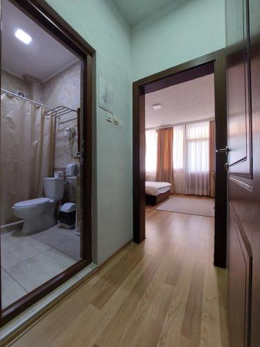 a bathroom with a toilet and a large glass door at Lakeview Hotel and Resort in Oteševo