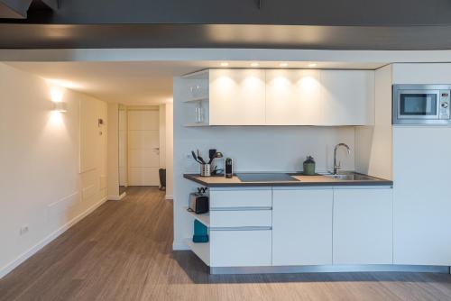 a kitchen with white cabinets and a sink at Suite Brunate - by MyHomeInComo in Como