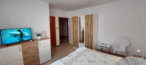 a bedroom with a bed and a television in it at Room Eta in Cres