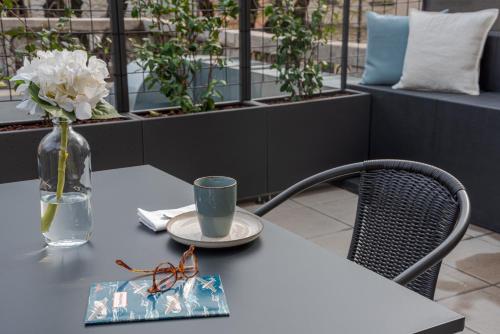 a table with a vase of flowers and a vase at Suite Brunate - by MyHomeInComo in Como