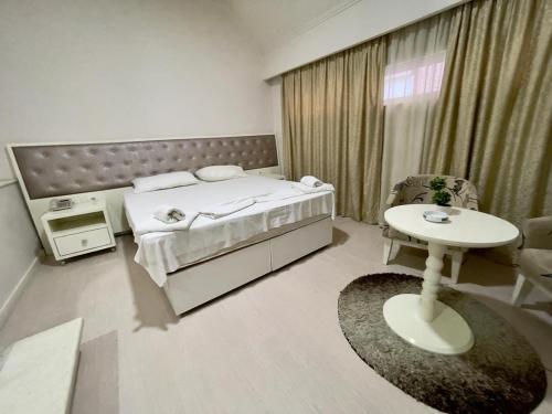 - une chambre avec un lit, une table et une fenêtre dans l'établissement Select City Center Hotel, à Tirana