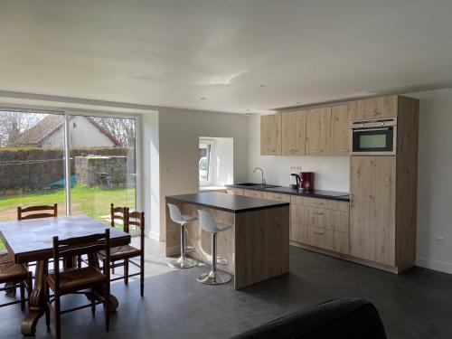 une cuisine et une salle à manger avec une table et des chaises dans l'établissement La Bulle du Quinze, à Mazaye