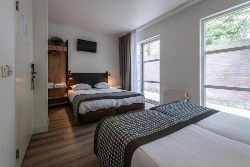 a hotel room with two beds and a window at Acostar Hotel in Amsterdam
