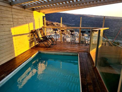 a balcony with a swimming pool on a house at צימר old school בחרמון לזוגות ומשפחות in Ein Kinya