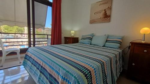 1 dormitorio con 1 cama y balcón en alquilaencanarias El Medano beach 1, en El Médano