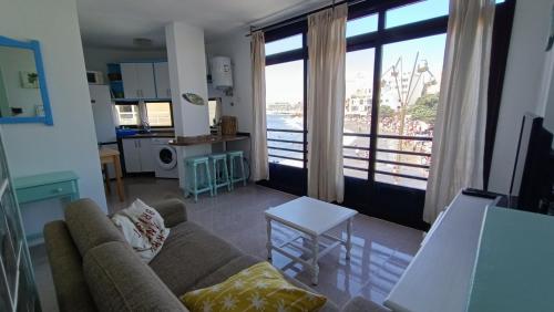 sala de estar con sofá y ventana grande en alquilaencanarias El Medano beach 1, en El Médano