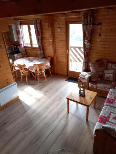 un salon avec une table et un canapé dans l'établissement chalet La Vallée, à La Bresse