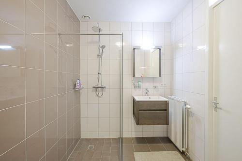 a bathroom with a shower and a sink at De Jutter in Den Helder