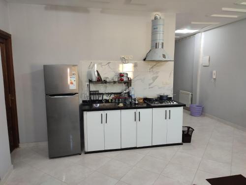 a kitchen with white cabinets and a refrigerator at The good stay 2 midelt in Midelt