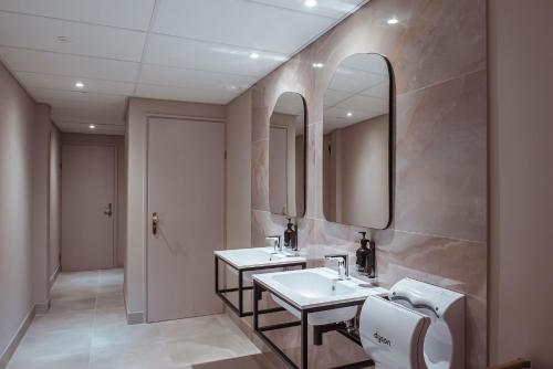 Baño con 2 lavabos y espejo en Boutique Hotel Restaurant BAL, en Echteld