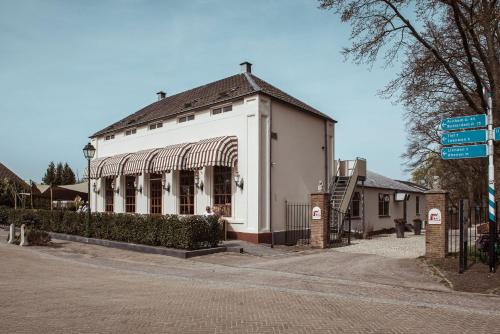 a white building on the corner of a street at Boutique Hotel Restaurant BAL in Echteld