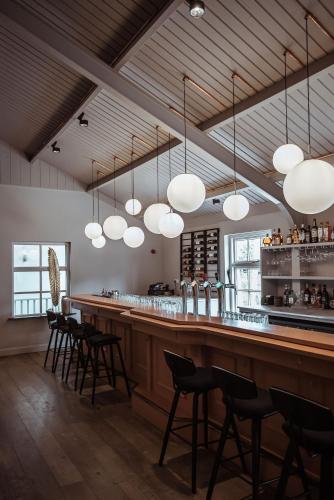 a bar in a restaurant with chairs and lights at Boutique Hotel Restaurant BAL in Echteld