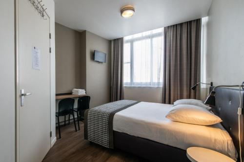 a hotel room with a bed and a desk at Acostar Hotel in Amsterdam