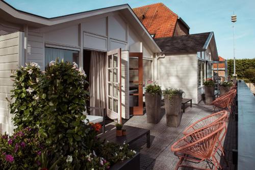 a patio with benches and flowers on a house at Boutique Hotel Restaurant BAL in Echteld