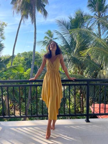 a woman in a yellow dress standing on a balcony at Tanzanite place in Tangalle