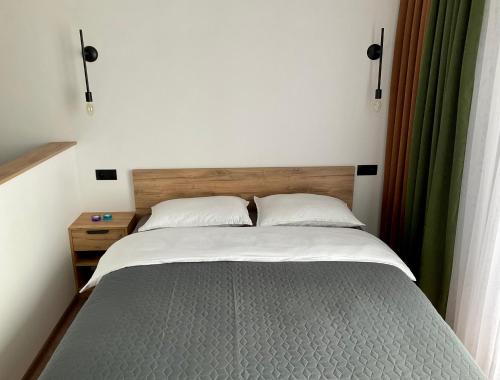 - une chambre avec un grand lit et une tête de lit en bois dans l'établissement Babi Home, à Batoumi