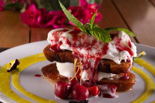 a plate with two pieces of bread with whipped cream and berries at Valtos Beach Hotel in Parga