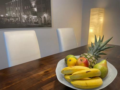 a plate of fruit on a wooden table at Am Weinberg - stilvoll, ruhig, zum wohlfühlen in Pfaffenweiler