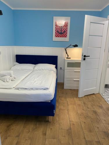 1 dormitorio con 1 cama con pared azul en Dom Gościnny Marzena en Międzyzdroje