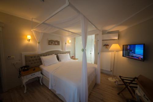 a bedroom with a white bed with a canopy at Biga Palas Hotel in Biga
