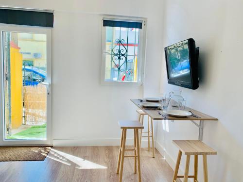 Pokój ze stołem ze stołkami i telewizorem w obiekcie Mini Loft Plaza España w mieście Jerez de la Frontera