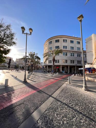 a cobblestone street with street lights and a building at Paris Square Apartments Downtown in Haifa
